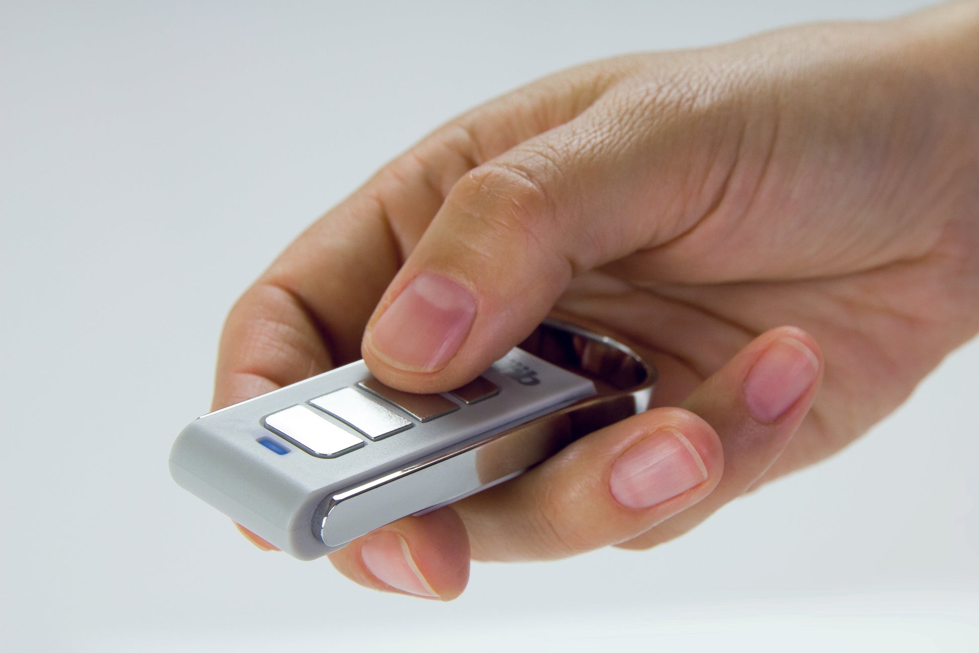 Hand holding a Quiko 4-Channel remote for automation.