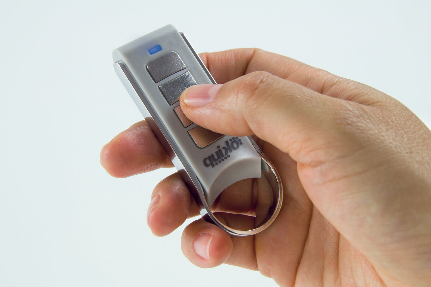 Hand holding Quiko 4-channel remote for automation.