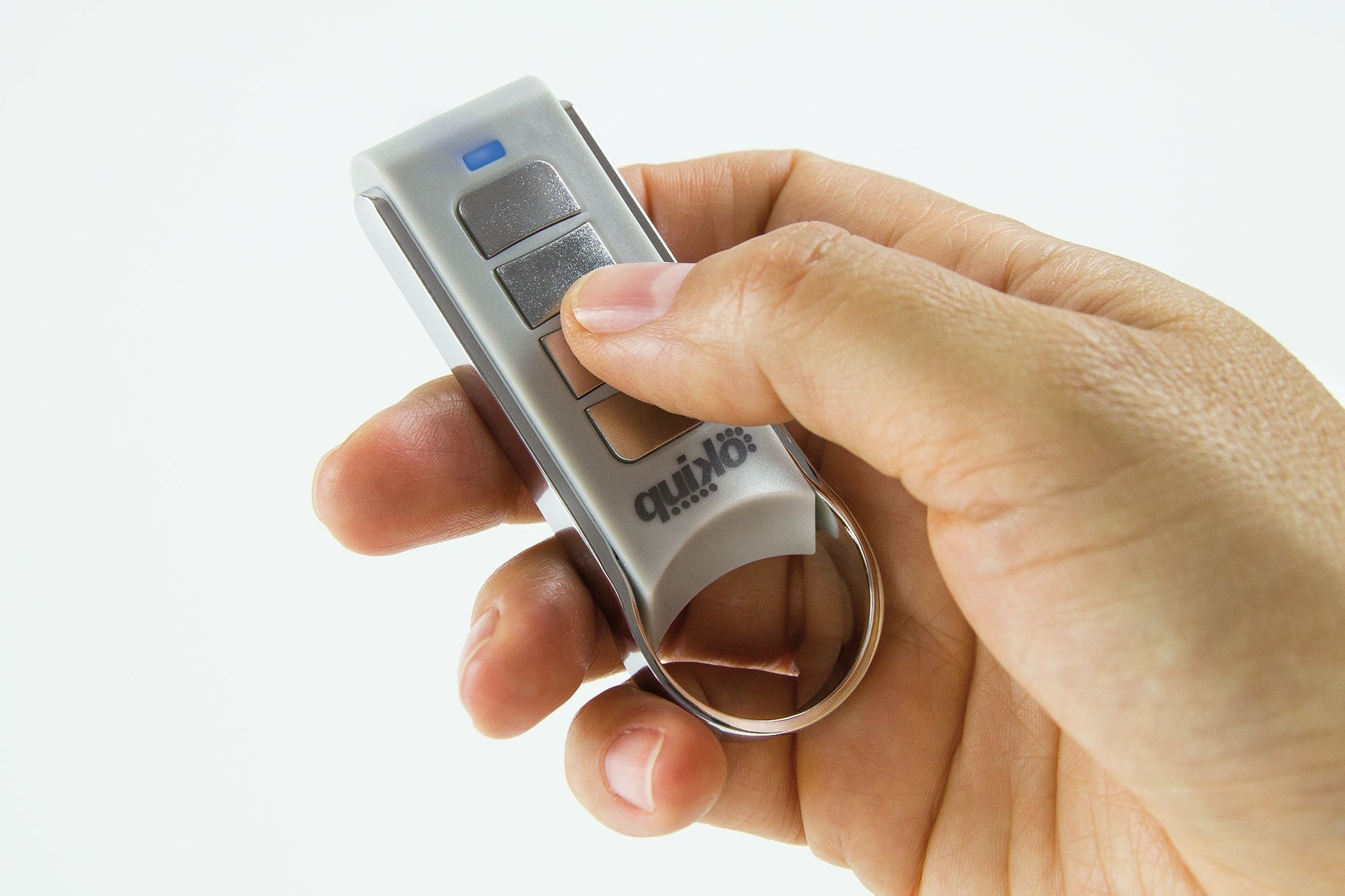 Hand holding Quiko 4-channel remote for automation.